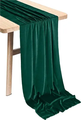 A green velvet table runner draped over a wooden table.