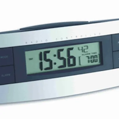 A close-up shot of a digital alarm clock displaying the time and alarm settings.