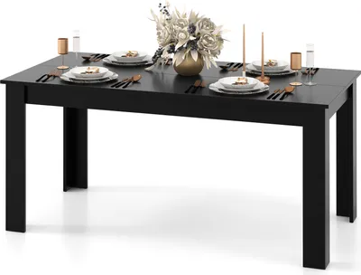 A black rectangular dining table set for a formal meal with place settings and a floral centerpiece.