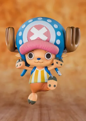 A figurine of the character Chopper from One Piece, depicted in a dynamic pose against a warm, textured background.