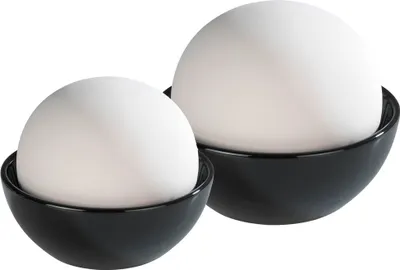 Two white spherical humidifiers sit in black bowls.