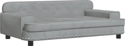 A light gray velvet dog sofa with tufted backrest and studded trim.