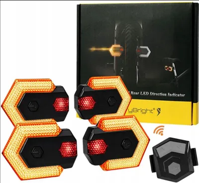 A product shot of bicycle LED turn signal lights and a remote control, with packaging in the background.