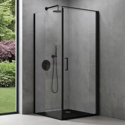 A modern black framed shower cabin with a shower head and controls, set against a textured gray wall and a window showing a garden.