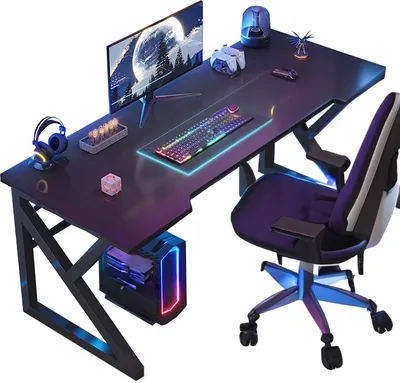 A gaming desk setup with a computer, monitor, keyboard, and chair, illuminated by colorful LED lights.