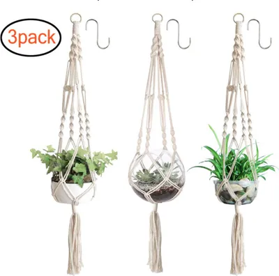 Three macrame plant hangers with plants and succulents.