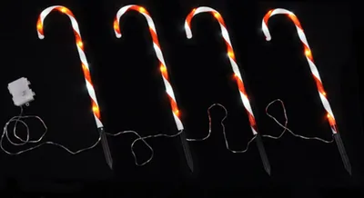 Four LED candy cane pathway lights with a black background.