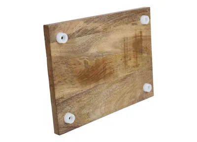 The underside of a wooden cutting board with four white feet, isolated on a white background.