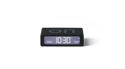 A black digital alarm clock is shown against a white background.