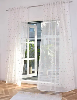 A window with sheer curtains and an open door.
