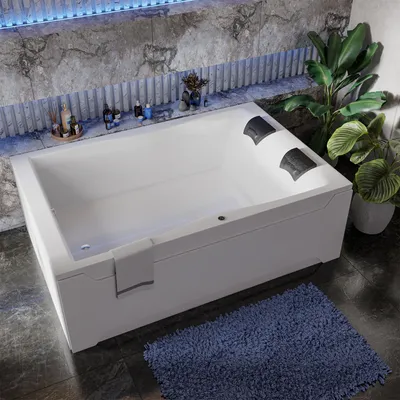 A modern bathroom with a white bathtub, blue rug, and plants.
