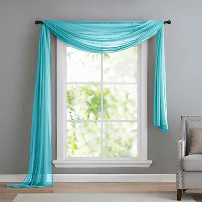 A turquoise sheer scarf draped over a window.