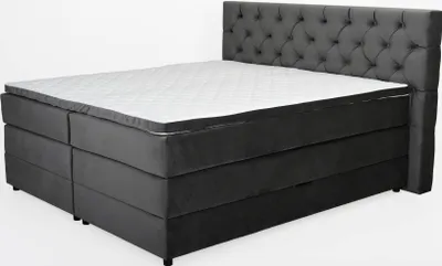 A tufted headboard bed with a mattress and topper, set against a white background.