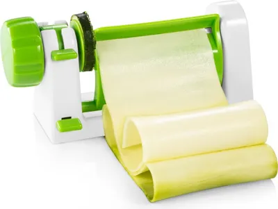 A close-up studio shot of a vegetable spiralizer with sliced zucchini coming out of it.