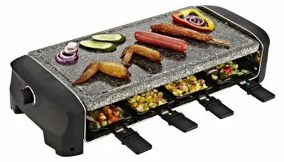 A raclette grill with food cooking on it.