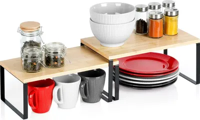 A kitchen shelf organizer with various kitchen items like bowls, plates, mugs, and jars.