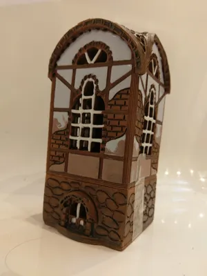 Das Keramikhaus ist in braunen, weißen und hellbraunen Tönen gehalten, mit einem Fachwerk-Design.
