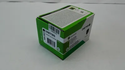A product box for a Lexmark toner cartridge is shown on a light gray surface.