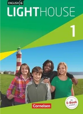 A group of four young people are standing in front of a lighthouse with a body of water in the background.