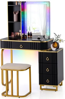 A black and gold LED vanity table with a stool and a side cabinet, set against a white background with colorful light effects emanating from the table.