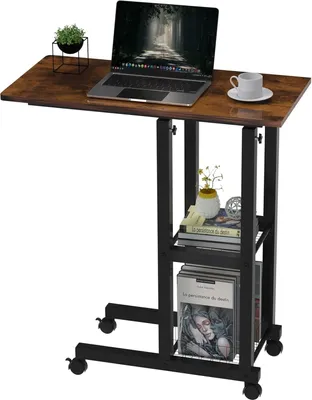 A mobile laptop table with shelves, a laptop, a plant, and a cup on a white background.