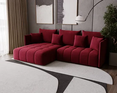 A modern living room with a red sectional sofa, abstract art on the wall, and a large rug.