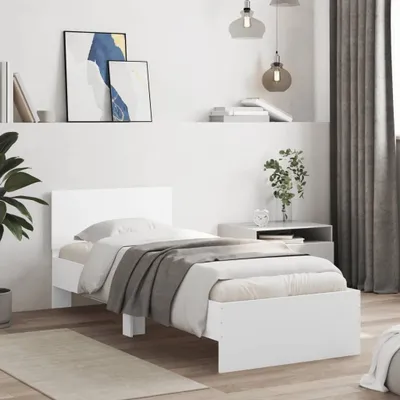 A white bed frame with bedding in a bedroom setting.