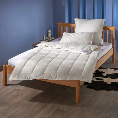 A neatly made bed with white bedding in a room with blue walls and wooden flooring.