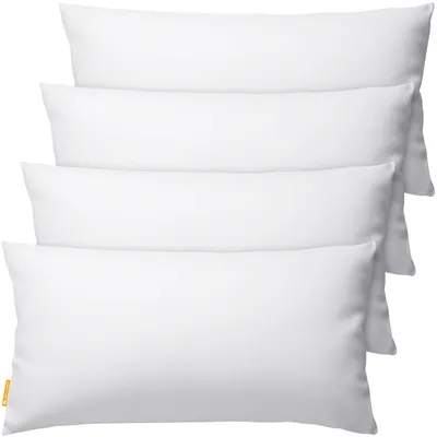 Four white pillows are stacked on top of each other against a white background.