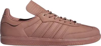 A side view of a pink Adidas Humanrace Samba sneaker.