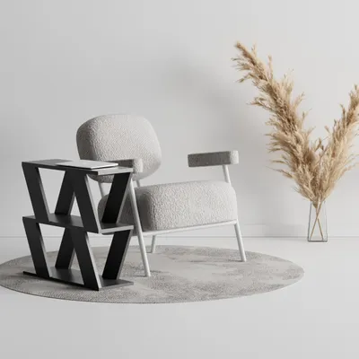 A modern armchair and a side table with a laptop on it, next to a vase with dried flowers.