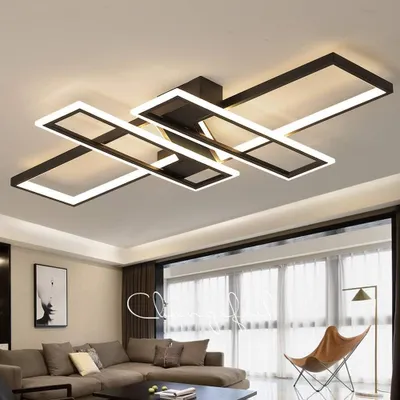 A modern living room with a sectional sofa, coffee table, and a large window with sheer curtains. A contemporary ceiling lamp is prominently displayed.