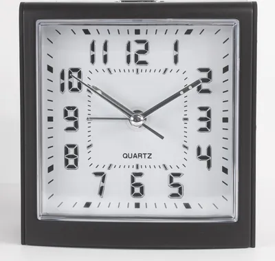 A close-up studio shot of a black analog alarm clock with a white face and silver hands.