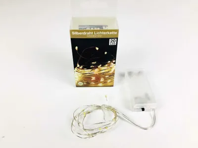 A product shot of a string of LED lights and its battery pack, with the product packaging in the background.