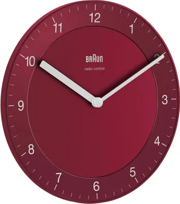 A close-up studio shot of a red Braun radio-controlled wall clock against a white background.