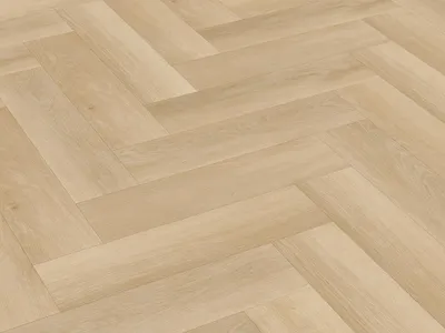 A close-up, angled view of a light-colored wooden floor laid in a herringbone pattern.