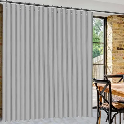 A room with a window and a dining table with chairs, partially obscured by a large gray curtain.