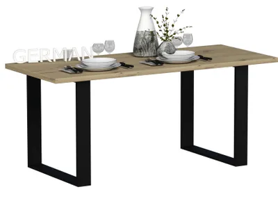 A dining table set with plates, glasses, and a vase.