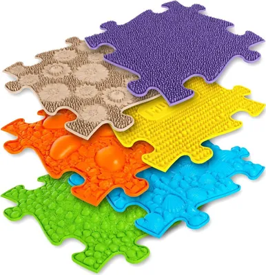 A collection of colorful, puzzle-shaped sensory mats with different textures.