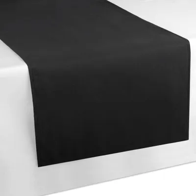 A black table runner is laid diagonally across a white surface, likely a table.