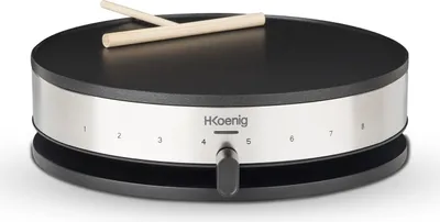 A H.Koenig crepe maker with two wooden spatulas resting on its surface.