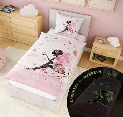 A child's bedroom with a bed dressed in fairy-themed bedding.