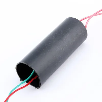 A close-up shot of a black cylindrical electronic component with red and green wires emerging from one end and pink wires from the other, set against a white background.