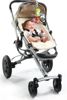 A baby sitting in a stroller with a mobile toy hanging above.