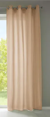 A beige curtain hangs in front of a window with trees visible outside.
