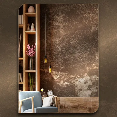 A mirror is displayed in a room setting, reflecting a bookshelf and a chair.