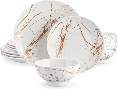 A set of white ceramic dishes with a gold marble-like pattern.