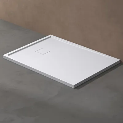 A white shower tray is shown on a gray floor with a brown wall in the background.