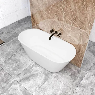 A freestanding oval bathtub in a modern bathroom with marble-like tiles.