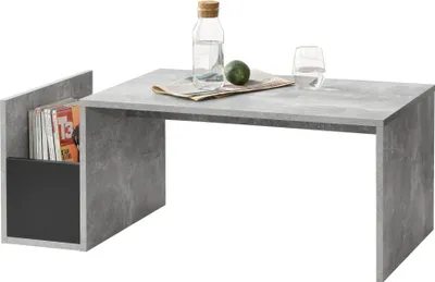 A modern coffee table with a built-in magazine rack, styled with a bottle of water, a glass, and a lime.